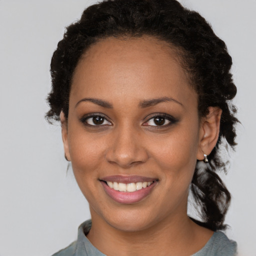 Joyful black young-adult female with medium  brown hair and brown eyes
