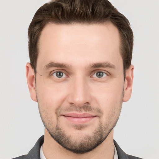 Joyful white young-adult male with short  brown hair and grey eyes