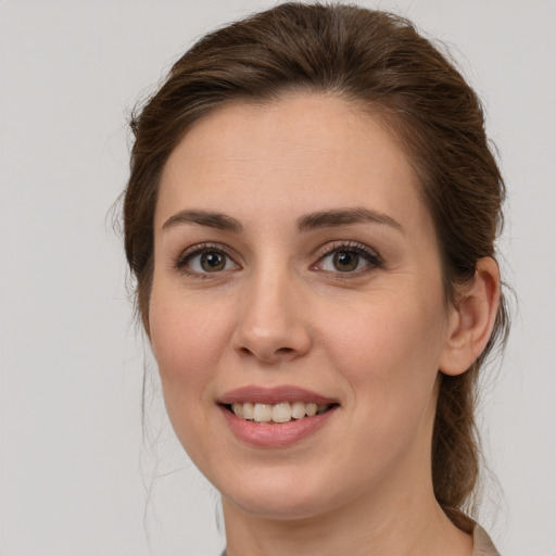 Joyful white young-adult female with medium  brown hair and green eyes