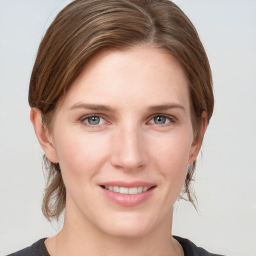 Joyful white young-adult female with medium  brown hair and grey eyes