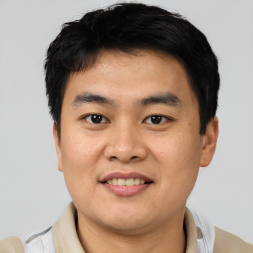 Joyful asian young-adult male with short  black hair and brown eyes
