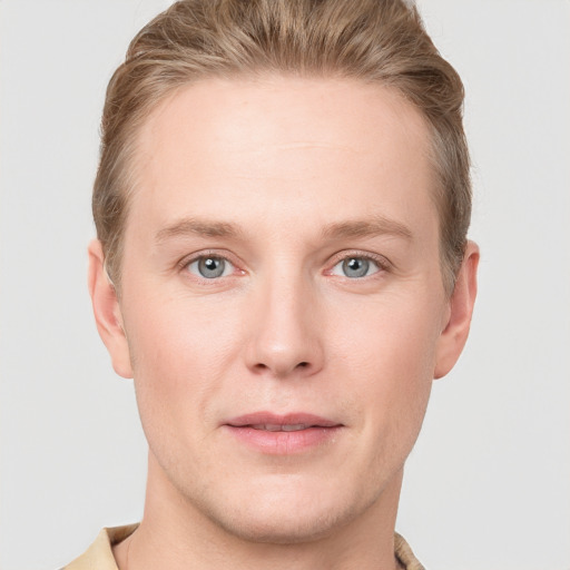 Joyful white young-adult male with short  brown hair and blue eyes