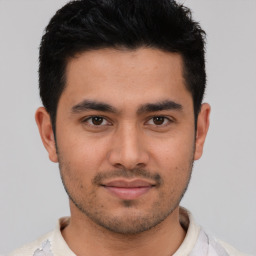 Joyful white young-adult male with short  black hair and brown eyes
