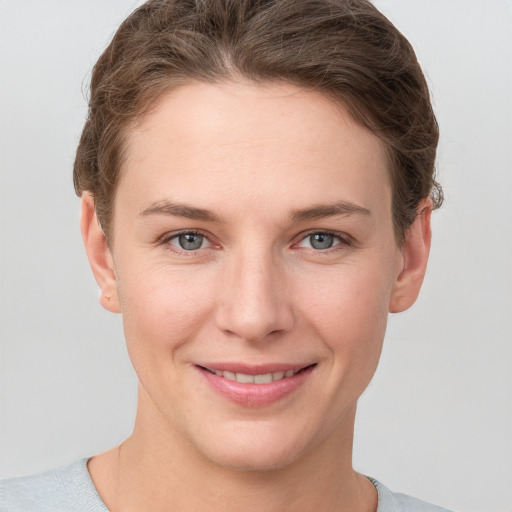 Joyful white young-adult female with short  brown hair and grey eyes