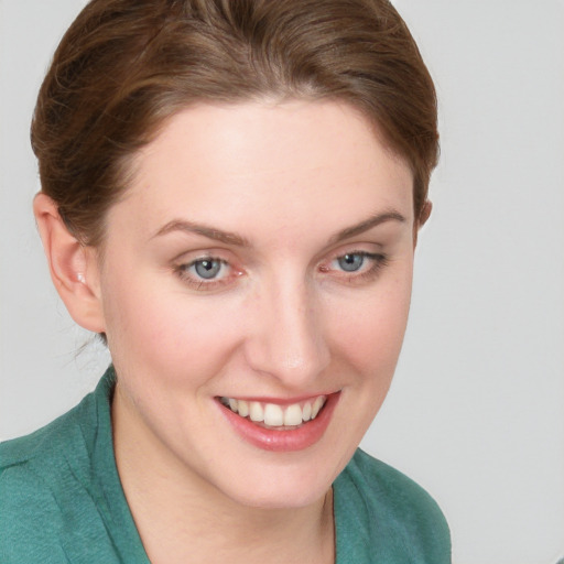 Joyful white young-adult female with short  brown hair and blue eyes