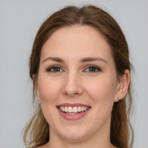 Joyful white young-adult female with long  brown hair and grey eyes