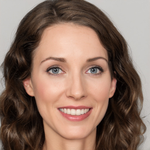 Joyful white young-adult female with medium  brown hair and green eyes