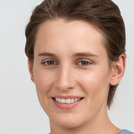 Joyful white young-adult female with short  brown hair and grey eyes