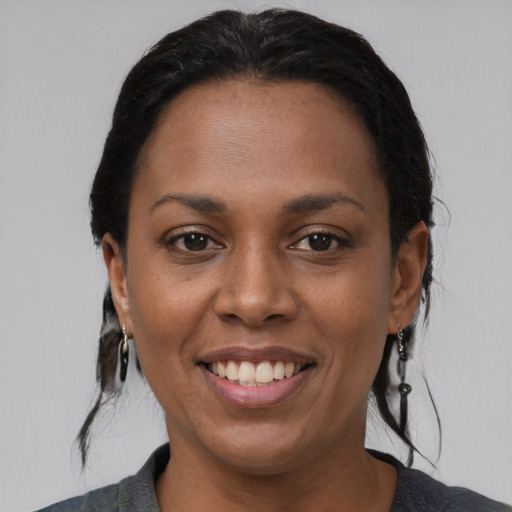 Joyful black young-adult female with medium  black hair and brown eyes