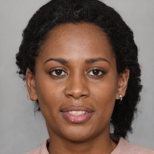 Joyful black young-adult female with short  black hair and brown eyes
