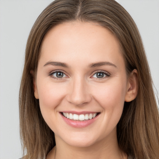 Joyful white young-adult female with long  brown hair and grey eyes