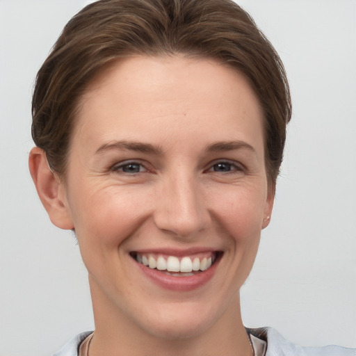 Joyful white young-adult female with short  brown hair and grey eyes