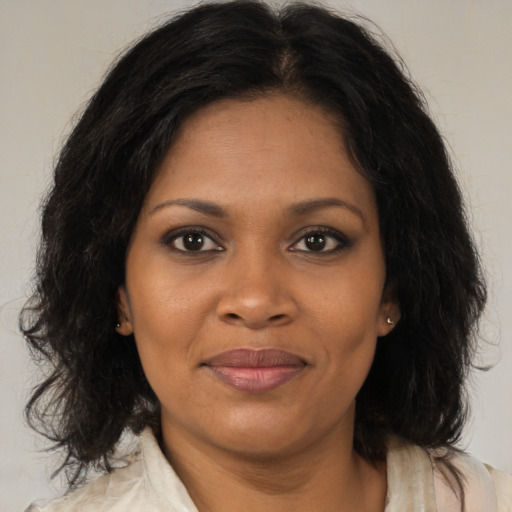 Joyful black adult female with medium  brown hair and brown eyes