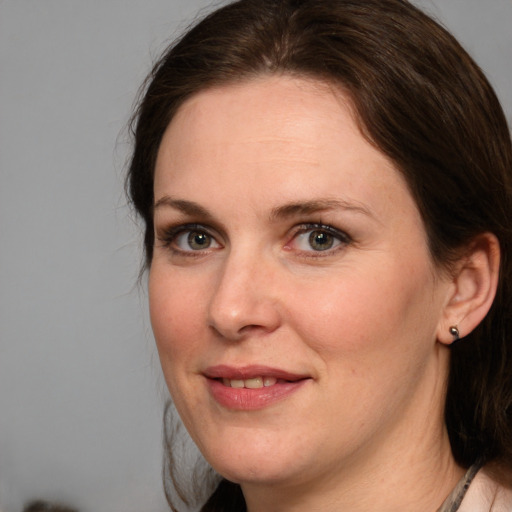 Joyful white adult female with medium  brown hair and grey eyes