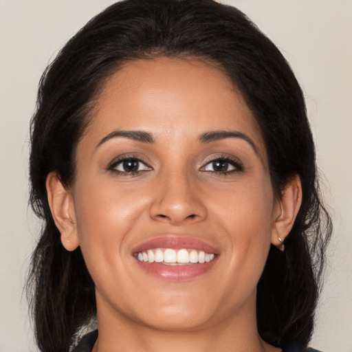 Joyful latino young-adult female with long  brown hair and brown eyes