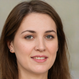 Joyful white young-adult female with long  brown hair and green eyes