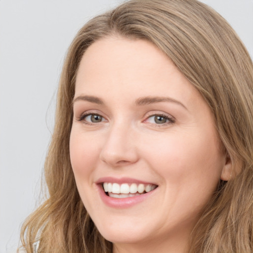 Joyful white young-adult female with long  brown hair and grey eyes