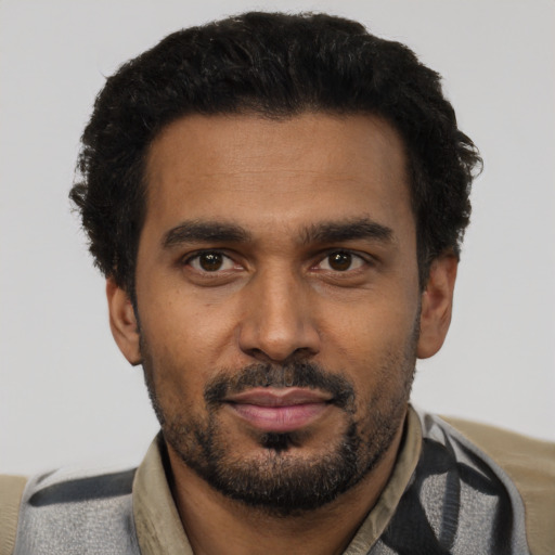 Joyful black young-adult male with short  black hair and brown eyes