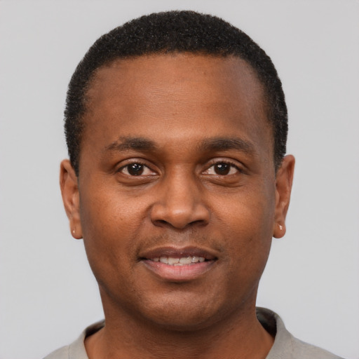 Joyful black young-adult male with short  brown hair and brown eyes