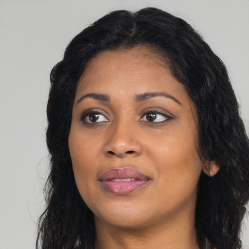 Joyful black young-adult female with long  black hair and brown eyes