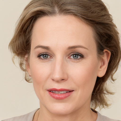 Joyful white adult female with medium  brown hair and grey eyes