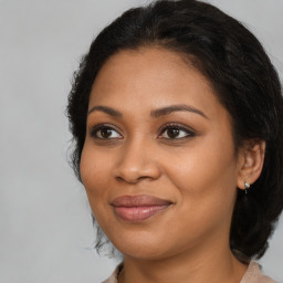 Joyful black young-adult female with long  brown hair and brown eyes