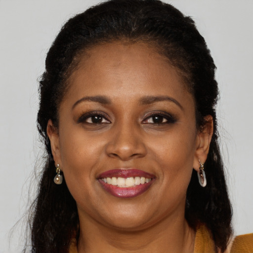 Joyful black young-adult female with long  brown hair and brown eyes