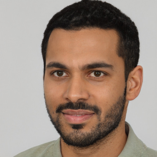 Joyful latino young-adult male with short  black hair and brown eyes