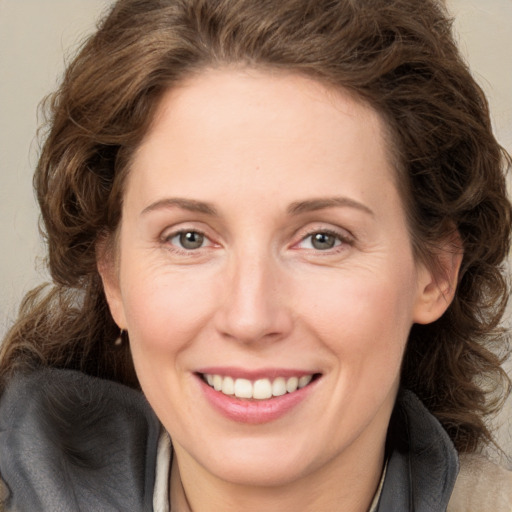 Joyful white adult female with medium  brown hair and blue eyes