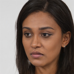 Joyful black young-adult female with long  brown hair and brown eyes