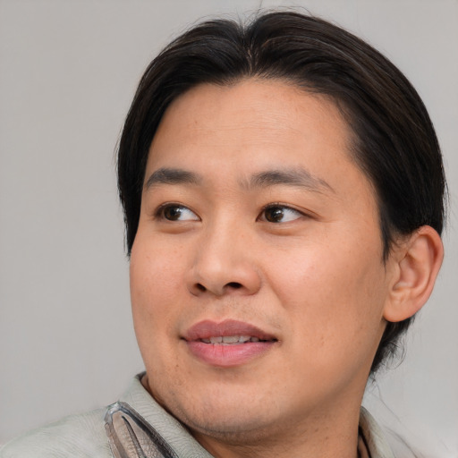 Joyful asian young-adult male with medium  brown hair and brown eyes