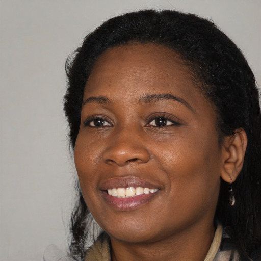 Joyful black young-adult female with long  brown hair and brown eyes