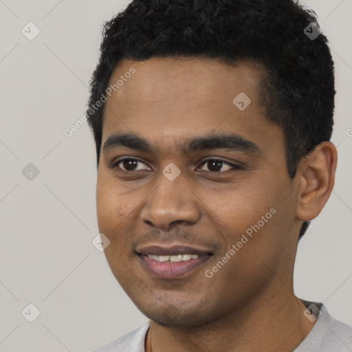 Joyful black young-adult male with short  black hair and brown eyes