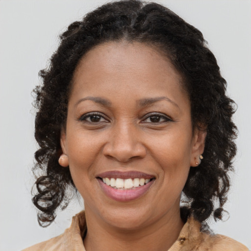 Joyful black adult female with long  brown hair and brown eyes