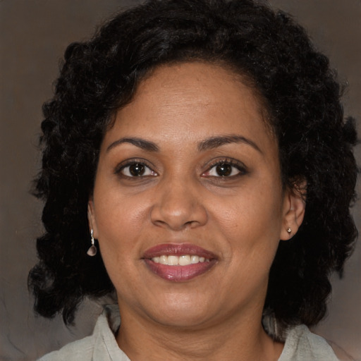 Joyful black adult female with long  brown hair and brown eyes