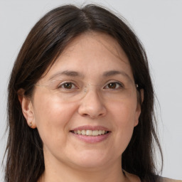 Joyful white adult female with long  brown hair and grey eyes