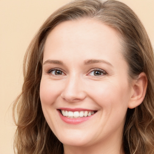 Joyful white young-adult female with long  brown hair and blue eyes