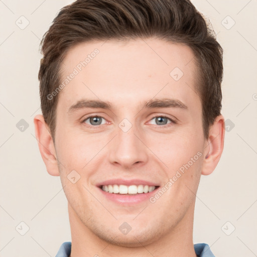 Joyful white young-adult male with short  brown hair and grey eyes