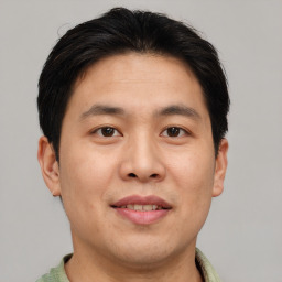 Joyful asian adult male with short  brown hair and brown eyes