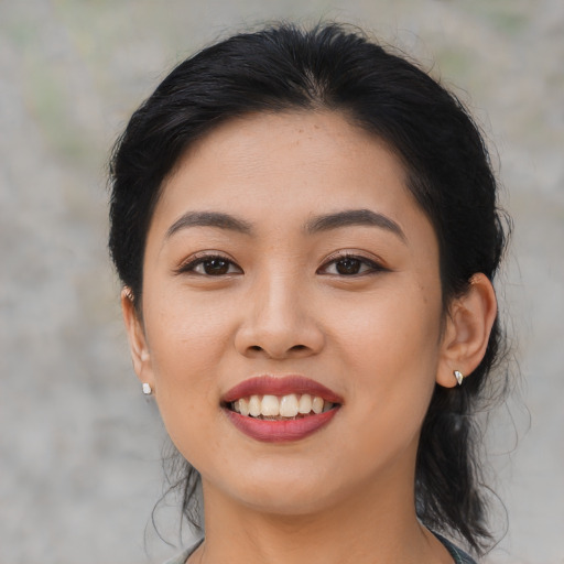 Joyful asian young-adult female with medium  black hair and brown eyes