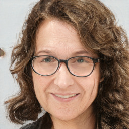 Joyful white adult female with long  brown hair and green eyes