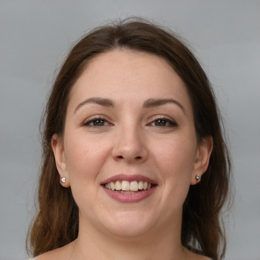 Joyful white young-adult female with medium  brown hair and grey eyes