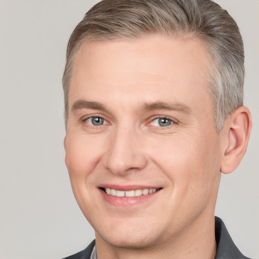 Joyful white adult male with short  brown hair and grey eyes