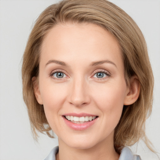 Joyful white young-adult female with medium  brown hair and blue eyes