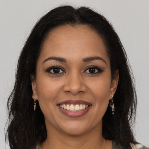 Joyful latino young-adult female with long  brown hair and brown eyes