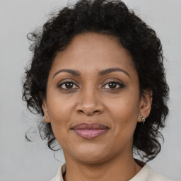 Joyful black adult female with medium  brown hair and brown eyes