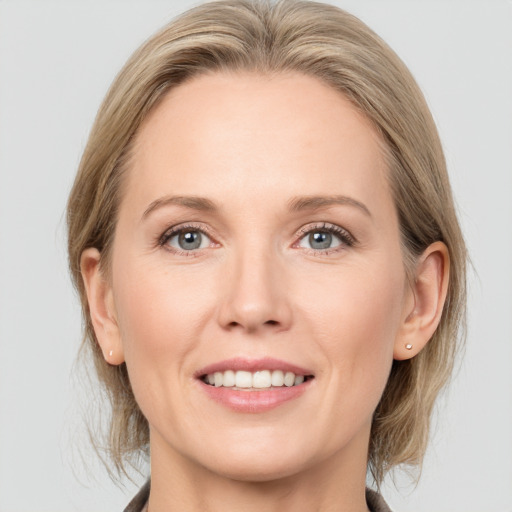 Joyful white adult female with medium  brown hair and grey eyes