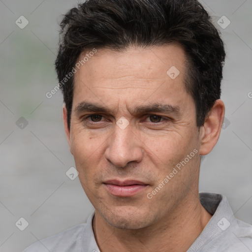 Joyful white adult male with short  black hair and brown eyes