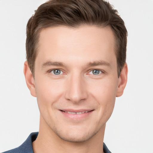 Joyful white young-adult male with short  brown hair and grey eyes