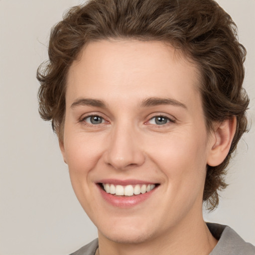 Joyful white young-adult female with short  brown hair and grey eyes